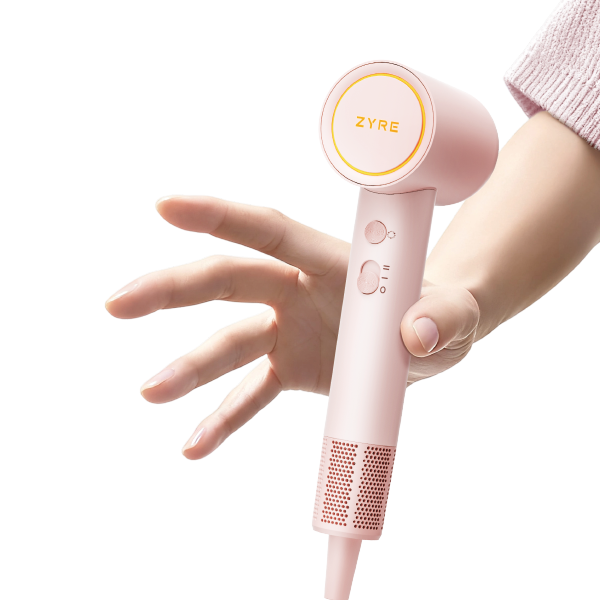 Pink handheld device with 'ZYRE' branding held by a hand on a white background